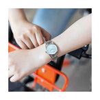 Montre femme Calvin Klein Dainty en acier poli argenté, cadran nacre blanc et cristaux éclatants, sur fond blanc pur, Maison Mercier.