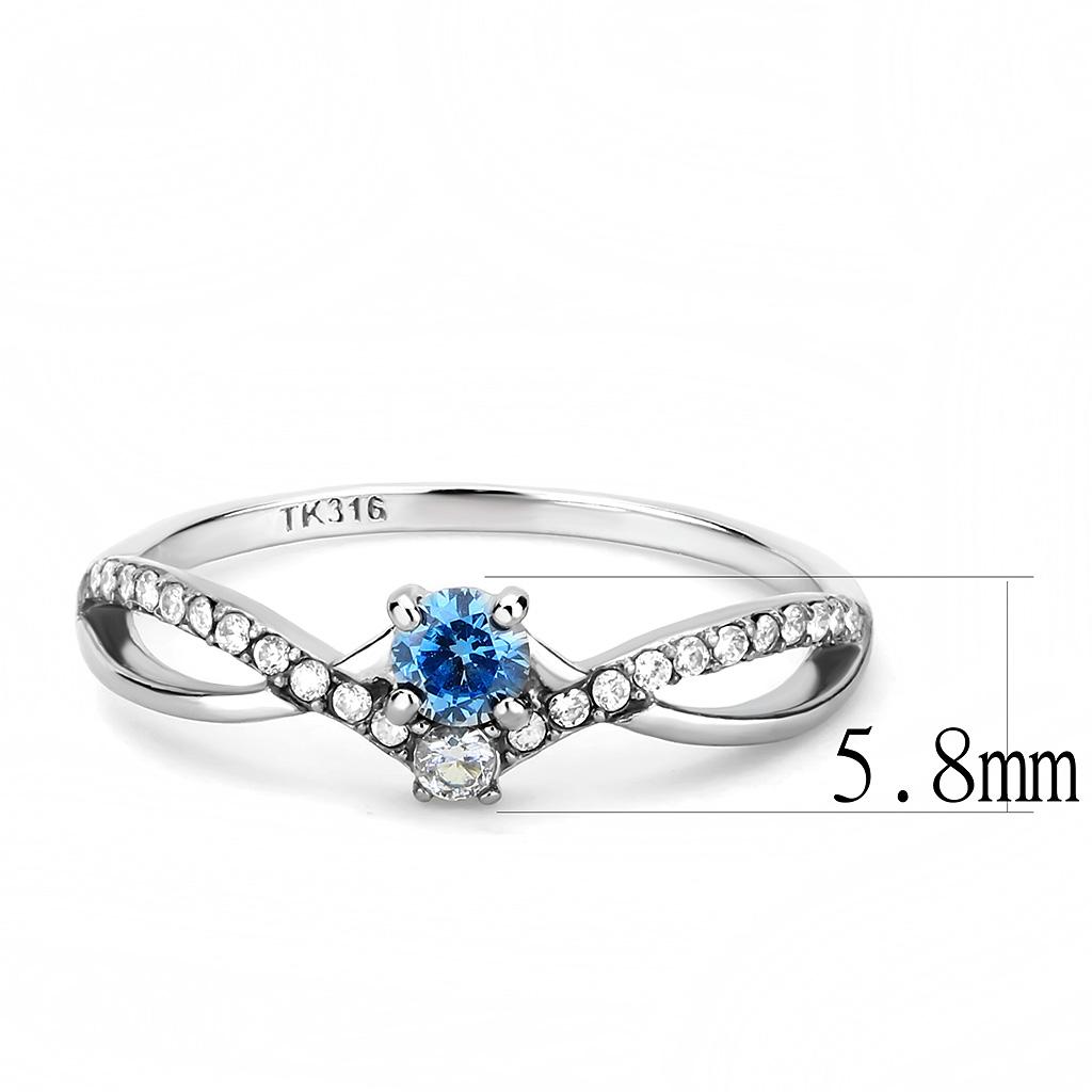 Vue latérale d'une bague solitaire en acier chirurgical TK316, topaze bleue océan, zircons pavés, avec indication de la largeur de 5.8mm et le poinçon TK316, Maison Mercier.