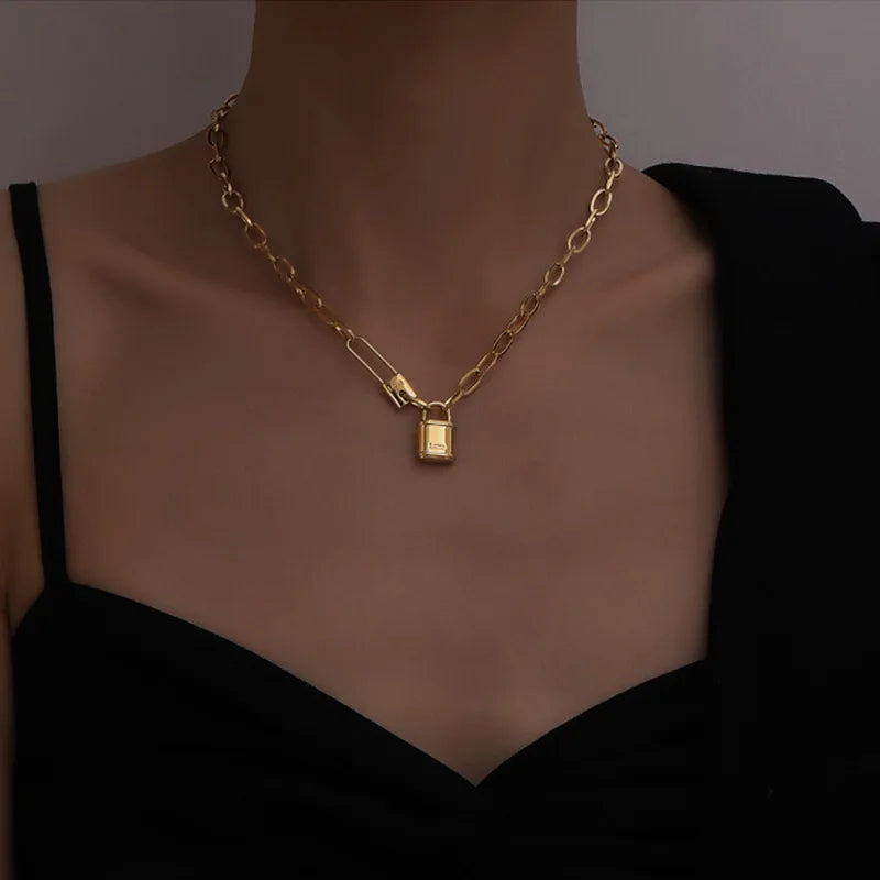 Vue d'ensemble du collier gourmette ovale doré, soulignant la texture des maillons et la brillance de l'acier inoxydable, Maison Mercier.