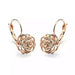 Détail d'une boucle d'oreille rose ajourée en finition or rose polie à la main, Maison Mercier.