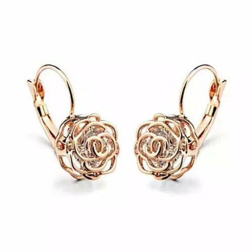 Détail d'une boucle d'oreille rose ajourée en finition or rose polie à la main, Maison Mercier.