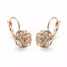 Détail d'une boucle d'oreille rose ajourée en finition or rose polie à la main, Maison Mercier.