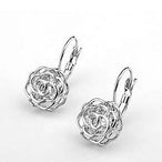 Détail d'une boucle d'oreille rose ajourée en finition argent rhodié polie à la main, Maison Mercier.