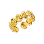 Détail d'une bague ajustable dorée en acier inoxydable, ornée d'un motif délicat de coquillages, Maison Mercier.