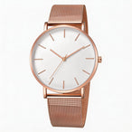 Montre féminine Maison Mercier, cadran noir épuré, bracelet maille milanaise finition or rose, portée au poignet avec un bracelet délicat à perles dorées.