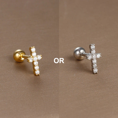 Gros plan artistique d'un piercing d'oreille fleur à cinq pétales en zircons, en acier chirurgical doré, sur fond bronze, Maison Mercier.