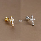 Gros plan artistique d'un piercing d'oreille fleur à cinq pétales en zircons, en acier chirurgical doré, sur fond bronze, Maison Mercier.