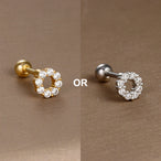 Vue rapprochée d'un piercing d'oreille en acier chirurgical doré, mettant en valeur la finesse du sertissage des zircons.
