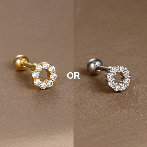 Vue rapprochée d'un piercing d'oreille en acier chirurgical doré, mettant en valeur la finesse du sertissage des zircons.