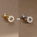 Vue rapprochée d'un piercing d'oreille en acier chirurgical doré, mettant en valeur la finesse du sertissage des zircons.