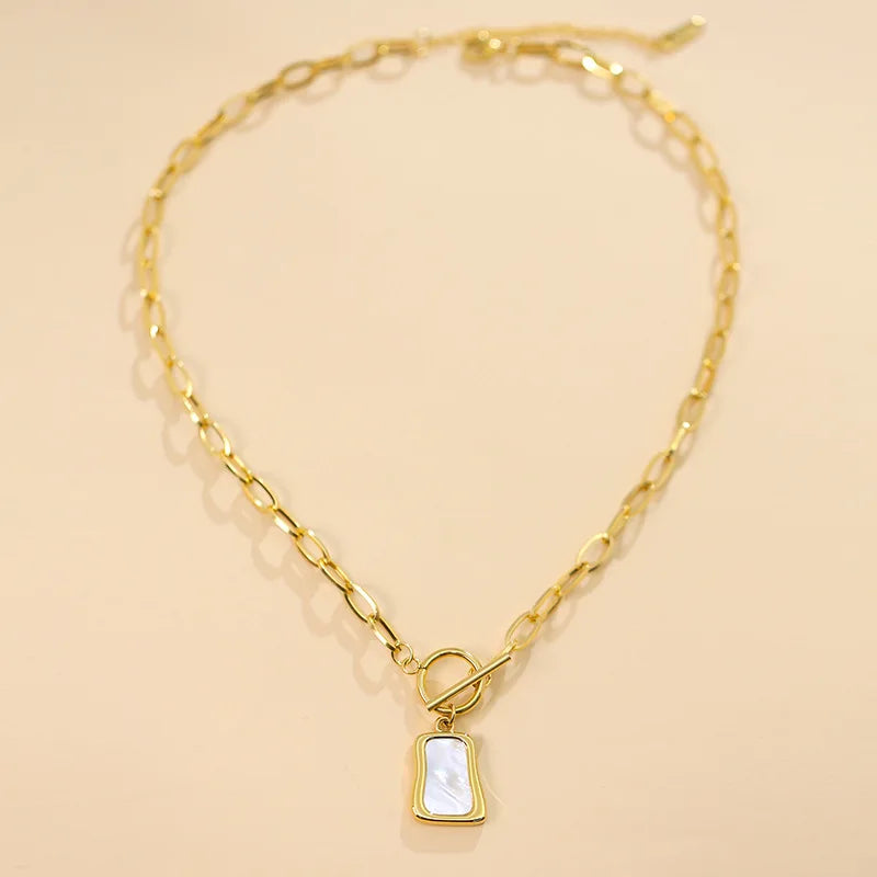Le pendentif en nacre, capturant les nuances de lumière, au cœur d'une création Maison Mercier.