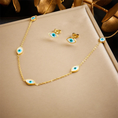 Gros plan sur une parure collier et puces d'oreilles mandala ajouré en acier doré et turquoise, Maison Mercier.