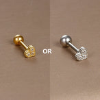 Détail d'un piercing d'oreille étoile à huit branches en zircons, en acier chirurgical doré, Maison Mercier.