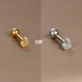 Détail d'un piercing d'oreille étoile à huit branches en zircons, en acier chirurgical doré, Maison Mercier.