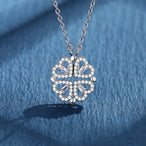 Collier pendentif transformable cœurs trèfle en acier doré et zirconia, présenté ouvert en ligne de cœurs et fermé en trèfle, sur fond bleu profond, Maison Mercier.