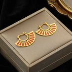 Détail d'une paire de boucles d'oreilles dorées en forme de demi-lune texturée et polie, Maison Mercier.