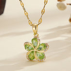 Vue d'ensemble de trois Colliers Pendentifs Floraux Maison Mercier, ornés de zircons blancs, verts et rouges, en acier doré.