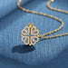 Collier pendentif transformable cœurs trèfle en acier doré et zirconia, présenté ouvert en ligne de cœurs et fermé en trèfle, sur fond bleu profond, Maison Mercier.