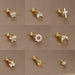 Détail d'un piercing d'oreille fleur à cinq pétales en zircons, en acier chirurgical doré, Maison Mercier.