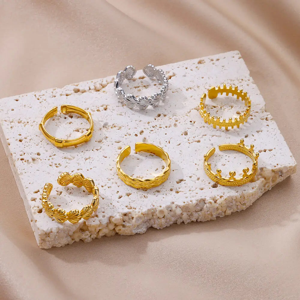 Détail d'une bague ajustable dorée en acier inoxydable, ornée d'un motif délicat de coquillages, Maison Mercier.