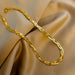 Détail d'une parure collier et bracelet tressés en maille serpent, présentant trois patines distinctes (or, argent, or rose), Maison Mercier.