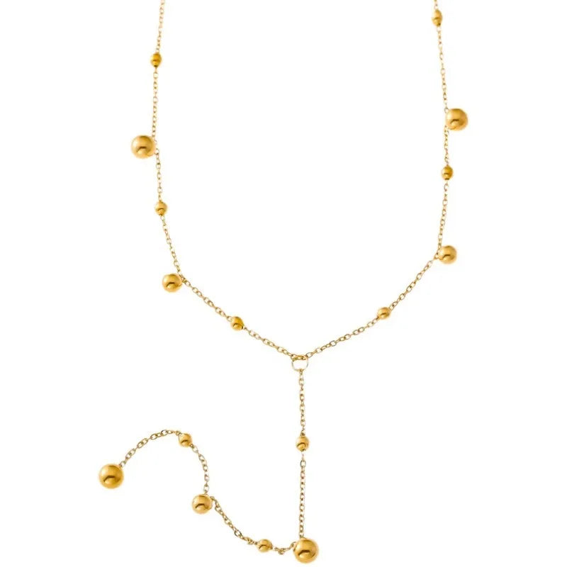 Présentation artistique du collier Lariat Y, soulignant la fluidité de son design et l'éclat de ses sphères.