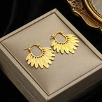 Détail d'une paire de boucles d'oreilles dorées en éventail avec une pierre opale irisée, Maison Mercier.