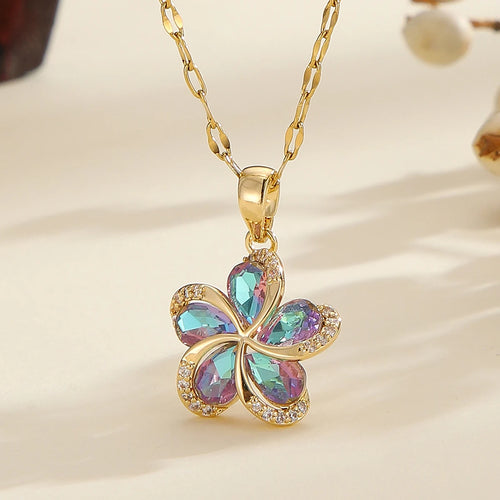 Vue d'ensemble de trois Colliers Pendentifs Floraux Maison Mercier, ornés de zircons blancs, verts et rouges, en acier doré.