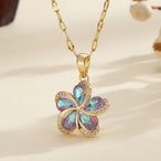 Vue d'ensemble de trois Colliers Pendentifs Floraux Maison Mercier, ornés de zircons blancs, verts et rouges, en acier doré.