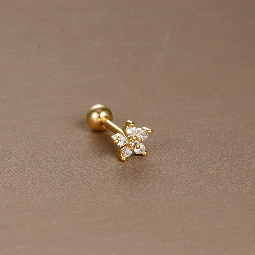 Détail d'un piercing d'oreille fleur à six pétales en zircons, en acier chirurgical doré, Maison Mercier.