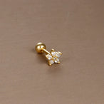 Détail d'un piercing d'oreille fleur à six pétales en zircons, en acier chirurgical doré, Maison Mercier.