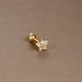 Détail d'un piercing d'oreille fleur à six pétales en zircons, en acier chirurgical doré, Maison Mercier.