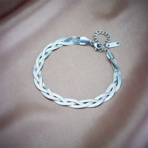 Détail d'une parure collier et bracelet tressés en maille serpent, présentant trois patines distinctes (or, argent, or rose), Maison Mercier.