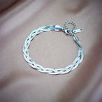 Détail d'une parure collier et bracelet tressés en maille serpent, présentant trois patines distinctes (or, argent, or rose), Maison Mercier.