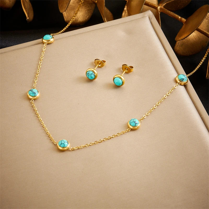 Détail d'une parure collier et puces d'oreilles œil protecteur en acier doré, Maison Mercier.