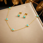 Détail d'une parure collier et puces d'oreilles petits cœurs ajourés en acier doré, Maison Mercier.
