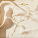 Fermoir détaillé du collier lariat Y en acier inoxydable doré, Maison Mercier.