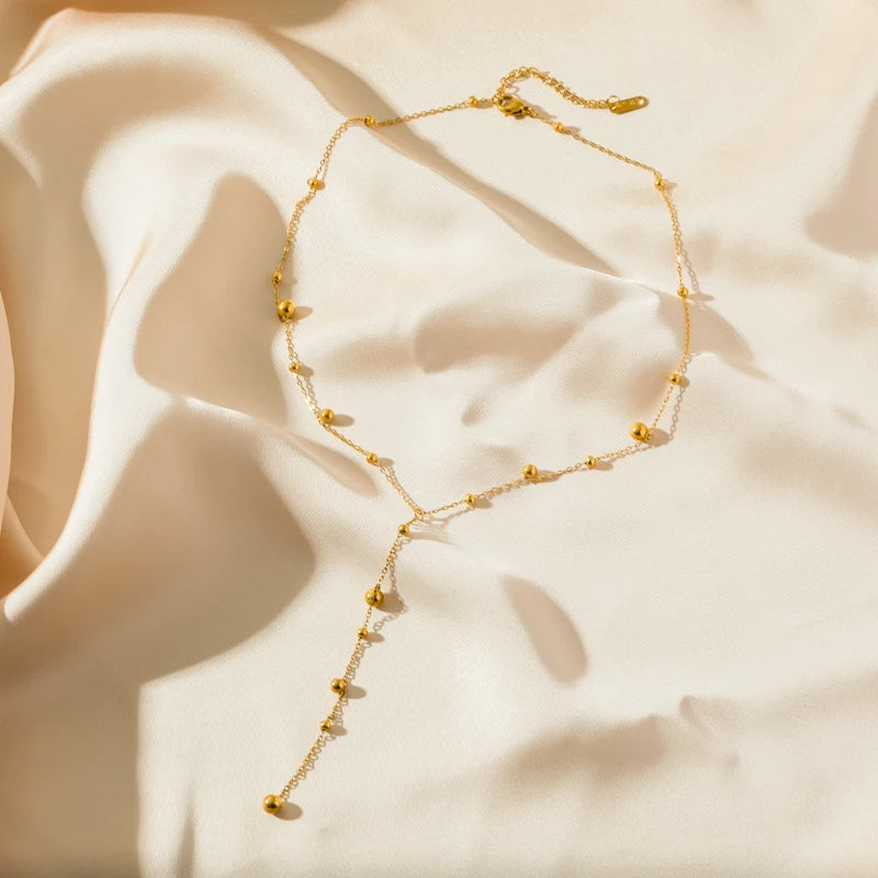Fermoir détaillé du collier lariat Y en acier inoxydable doré, Maison Mercier.