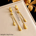 Détail des boucles d'oreilles pendantes Goutte d'Eau en acier doré, avec leurs dimensions précises de 7.5 cm (2.95 inch) et un poids de 14g (0.5oz), Maison Mercier.