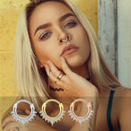 Gros plan sur un piercing clicker septum en acier chirurgical argenté orné de zircons taille marquise, avec un détail de goutte scintillante, Maison Mercier.