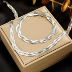 Détail d'une parure collier et bracelet tressés en maille serpent, présentant trois patines distinctes (or, argent, or rose), Maison Mercier.