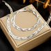 Détail d'une parure collier et bracelet tressés en maille serpent, présentant trois patines distinctes (or, argent, or rose), Maison Mercier.