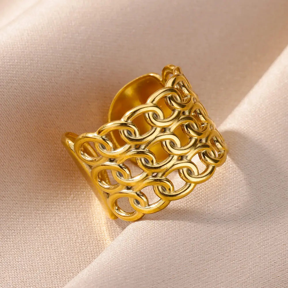 Bague large ajourée à motif géométrique complexe en acier inoxydable doré poli, Maison Mercier.