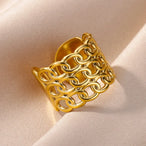 Bague large ajourée à motif géométrique complexe en acier inoxydable doré poli, Maison Mercier.