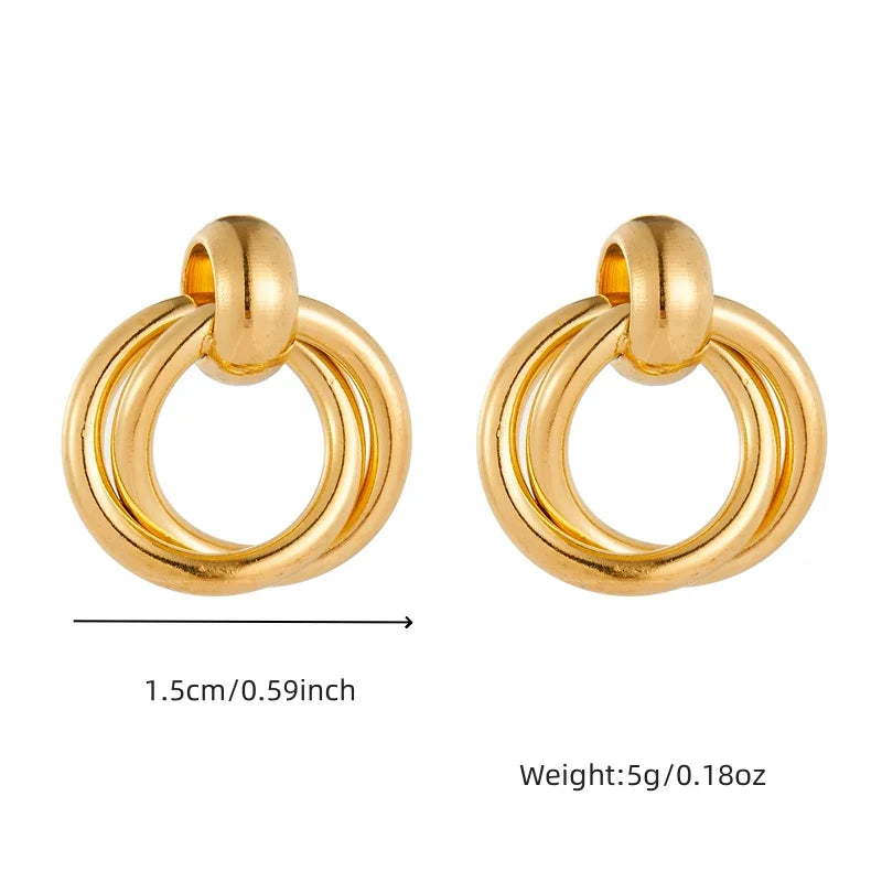 Paire de boucles d'oreilles puces avec perle blanche et monture carrée en acier inoxydable doré, Maison Mercier.