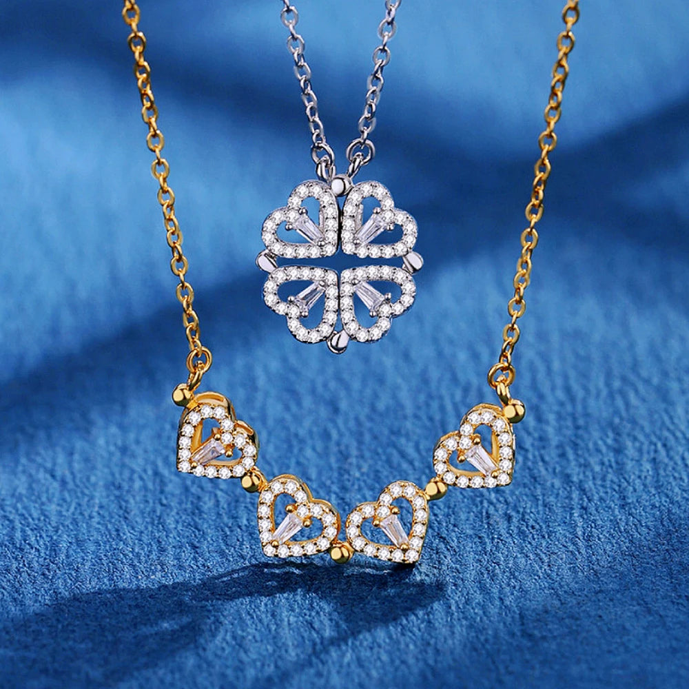 Collier pendentif transformable cœurs trèfle en acier doré et zirconia, présenté ouvert en ligne de cœurs et fermé en trèfle, sur fond bleu profond, Maison Mercier.