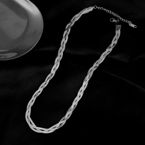 Détail d'une parure collier et bracelet tressés en maille serpent, présentant trois patines distinctes (or, argent, or rose), Maison Mercier.