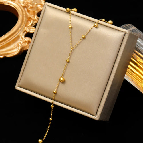 Détail de la chaîne fine du collier lariat Y, soulignant la qualité de l'acier inoxydable poli.
