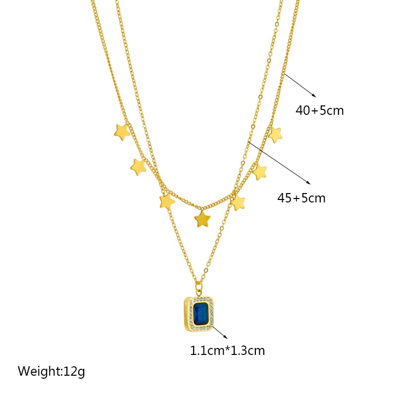 Collier femme double chaîne dorée en acier inoxydable 316L, agrémenté de multiples étoiles et d'un pendentif rectangulaire serti d'une pierre bleue, dimensions 1.1cm*1.3cm, longueurs 40+5cm et 45+5cm, poids 12g.