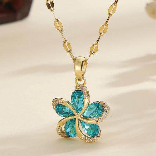 Vue d'ensemble de trois Colliers Pendentifs Floraux Maison Mercier, ornés de zircons blancs, verts et rouges, en acier doré.